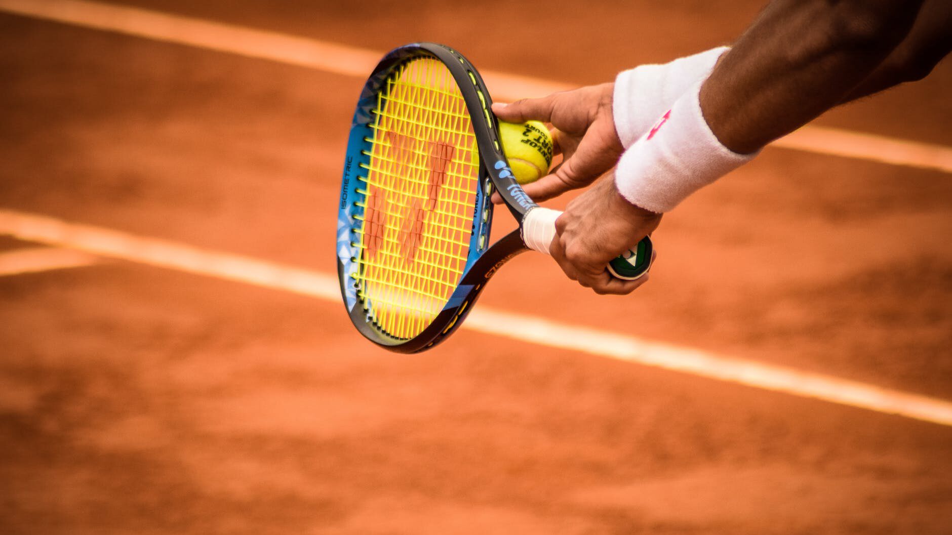 close up photo of person holding tennis racket and ball